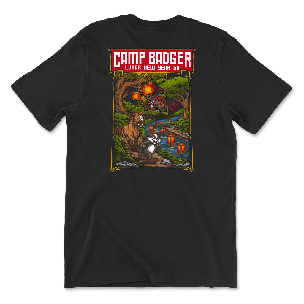 Back view of a black t-shirt for the Camp Badger Lunar New Year 5K. The large rectangular graphic features a festive night scene with a badger and a horse standing by a river lit by glowing red lanterns. The text 'CAMP BADGER' is displayed in bold at the top, followed by 'LUNAR NEW YEAR 5K' against a background of a forest, a bridge, and fireworks in the sky.