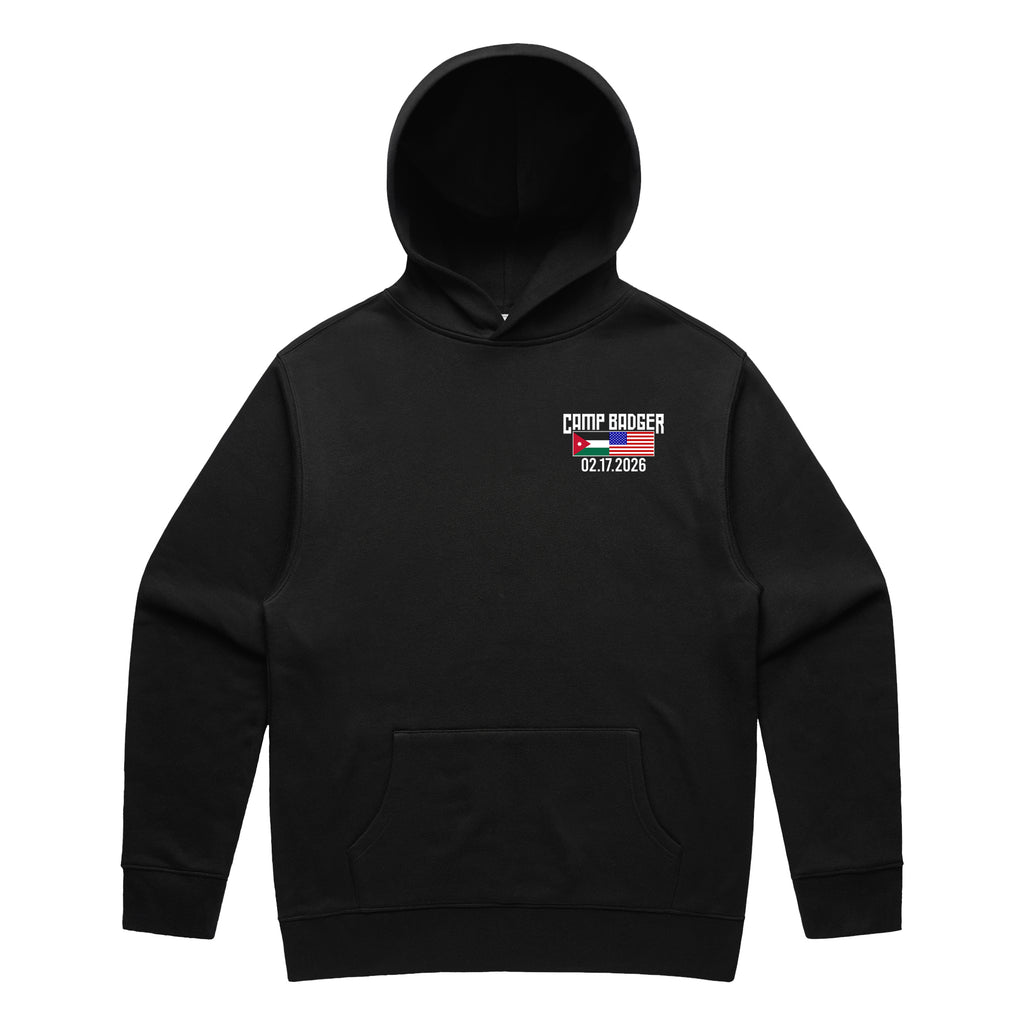 Front view of a black pullover hoodie for the Camp Badger Lunar New Year 5K. The left chest features a small graphic with the text 'CAMP BADGER' above the date '02.17.2026.' The design includes the national flags of Jordan and the United States side-by-side.